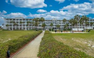 Un gran edificio blanco con un parque enfrente. en Grand Caribbean 316 Community Pool Access Minutes to the ocean front, en Perdido Key