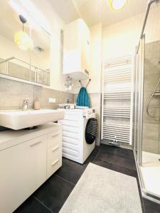 a white bathroom with a sink and a shower at 123 Apartment Graz - top 1 in Graz
