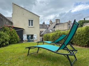 twee stoelen in de tuin van een huis bij Les chats pitres Maison au calme rénovée avec jardin, terrasse aménagée, transats, abri à vélo, parking gratuit, 5 mn à pied du centre Bayeux proche des plages du débarquement in Bayeux