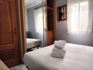 2 toallas están apiladas en una cama en una habitación en La habitación de Santa Eulalia, en Hospitalet de Llobregat