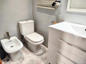 Un baño con un inodoro blanco y un lavabo. en La habitación de Santa Eulalia, en Hospitalet de Llobregat