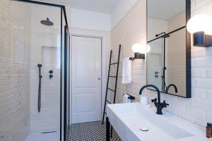 een witte badkamer met een wastafel en een douche bij Casa Giallo village home-by Italian Apartaments in Lenno +31 foto's