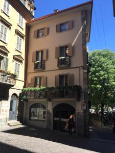 un edificio con una mujer parada frente a él en La Torre Bergamo House, en Bérgamo