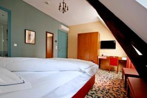 a bedroom with a large white bed and a desk at Maison d'hôtes Le Manoir de Contres in Contres