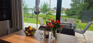 a table with a bowl of fruit and flowers on it at Domki nad zalewem in Gołdap