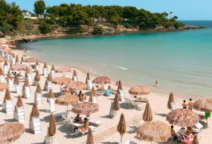 a group of umbrellas and chairs on a beach at Villa Ciaky in Leporano Marina