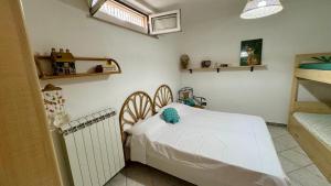 a bedroom with a white bed and a radiator at Villa Ciaky in Leporano Marina