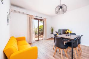 a living room with a yellow couch and a table at Gran Sol Family 7 in Felanitx