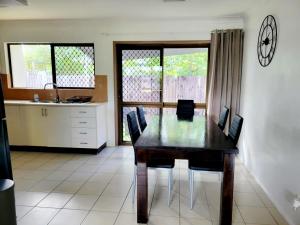 a kitchen with a dining room table and a clock on the wall at Chill out space close to town in Westcourt