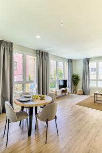 a living room with a table and chairs at Apartamentos Olivia by gaiarooms in Bilbao