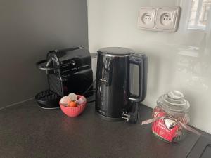 una cafetera y un bol de fruta en una barra en Residence Drobného apartmán Park, en Brno