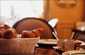 uma cesta de pão e ovos sobre uma mesa em Maison d'hôtes Le Manoir de Contres em Contres