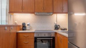 a kitchen with wooden cabinets and a stainless steel refrigerator at Villa28 Harmony in Paleros
