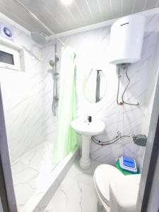 a white bathroom with a toilet and a sink at Meymandos in Tossor