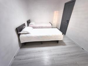 two beds in a room with white walls and wooden floors at Meymandos in Tossor