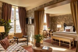 a bedroom with a bed and a living room at Hôtel Aubépine in Paris
