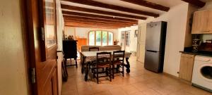 a kitchen and dining room with a table and a refrigerator at Malicroix in Arles +40 photos