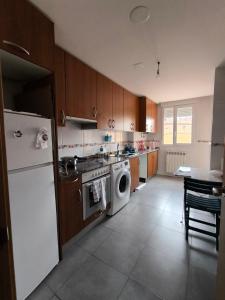 a kitchen with a stove and a washing machine at Rincon Confort in Villamediana de Iregua