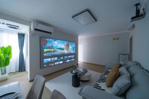 Una sala de estar con un sofá y un televisor de pantalla plana. en Downtown, 2BR 1LR 1KT 1BA, near Pedestrian St, the Bund, Pearl Tower, en Shanghái