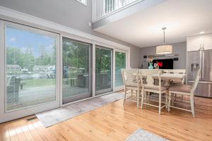 a dining room with sliding glass doors and a table and chairs at Gorgeous Torch River 3BDR Home Minutes to the Sandbar 8015 in Rapid City