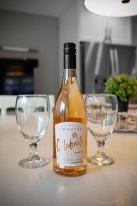 a bottle of wine sitting next to two wine glasses at Gorgeous Torch River 3BDR Home Minutes to the Sandbar 8015 in Rapid City +45 photos