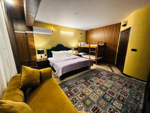 a hotel room with a bed and a couch at Royal Serviced Cottages in Murree