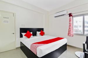 Un dormitorio con una cama grande con almohadas rojas. en Hotel O HILL 9, en Hyderabad