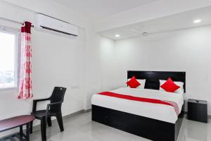 Un dormitorio con una cama, un escritorio y una silla. en Hotel O HILL 9, en Hyderabad