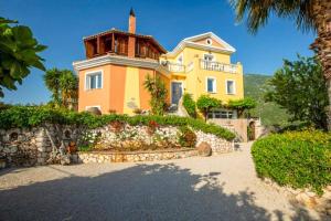 a large yellow house with a stone wall at Villa Octavius in Ráchi