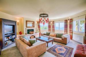 a living room with two couches and a tv at Villa Octavius in Ráchi
