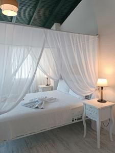 a bedroom with a white bed with a canopy at Tepe Hotel in Alaçatı