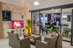 a living room with chairs and a tv and a table at Bayram Hotel in Çeşme