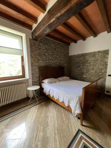 a bedroom with a large bed in a stone wall at Sant'Andrea - Monticello Apartments in Medesano