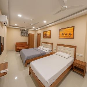 普杰StayGuru Park View Residency的一间有两张床和一台电视的卧室