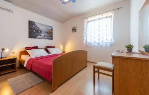 パグにある2 Bedroom Nice Apartment In Pagのベッドルーム1室(赤いベッドカバー、窓付)