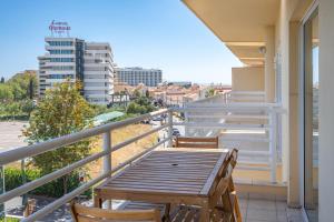 a balcony with a wooden table and chairs at Vilamoura Central 2 Bedroom Flat in Vilamoura