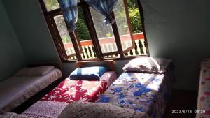 una camera con due letti davanti a una finestra di kenthomestay a Nagarkot