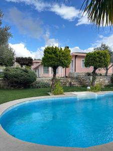 une grande piscine bleue devant une maison dans l'établissement Villa Palm Foçaköy, à Foça
