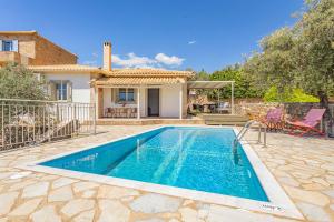 a swimming pool in front of a house at Villa Dafne in Pírgos
