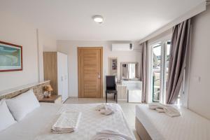 a bedroom with a bed and a desk and a chair at Bayram Hotel in Çeşme +54 photos