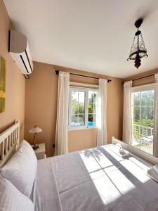 une chambre avec un grand lit et deux fenêtres dans l'établissement Villa Palm Foçaköy, à Foça