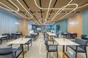 a dining room with tables and chairs at Atour Hotel Suzhou Wujiang Suzhou Bay in Suzhou