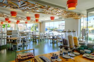 a dining room with tables and chairs and windows at Pandream Hotel Apartments in Paphos