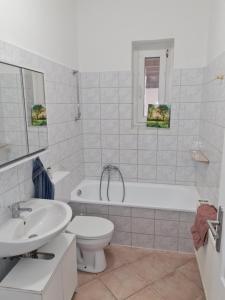 a bathroom with a sink and a toilet and a tub at Ferienwohnung am Schloss in Eckartsberga