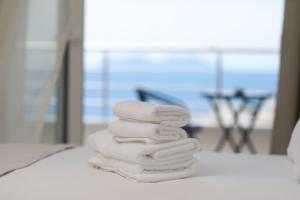 a stack of four towels stacked on a bed at Villa Christianna Free Parking in Vlorë +211 photos
