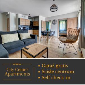 a living room with a blue couch and a table at Apartamenty City Center Cicha 8 in Krynica Zdrój