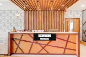 um hall de entrada com uma mesa com um cartaz em Palette Hotel And Resort Anand Formerly Hotel La Casa Inn em Anand