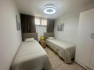a bedroom with two beds and a window at Seaside Two Bedroom Apartment in Los Cristianos +5 photos