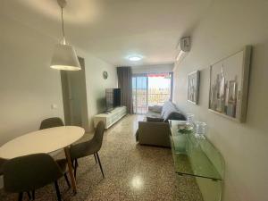a living room with a table and a couch at Seaside Two Bedroom Apartment in Los Cristianos
