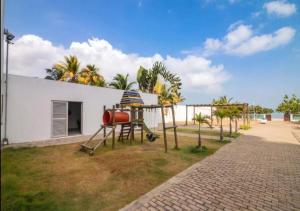 a playground in front of a white building with palm trees at Apto De 3 Hab con Vista y Salida directa Al Mar in Estación El Salto